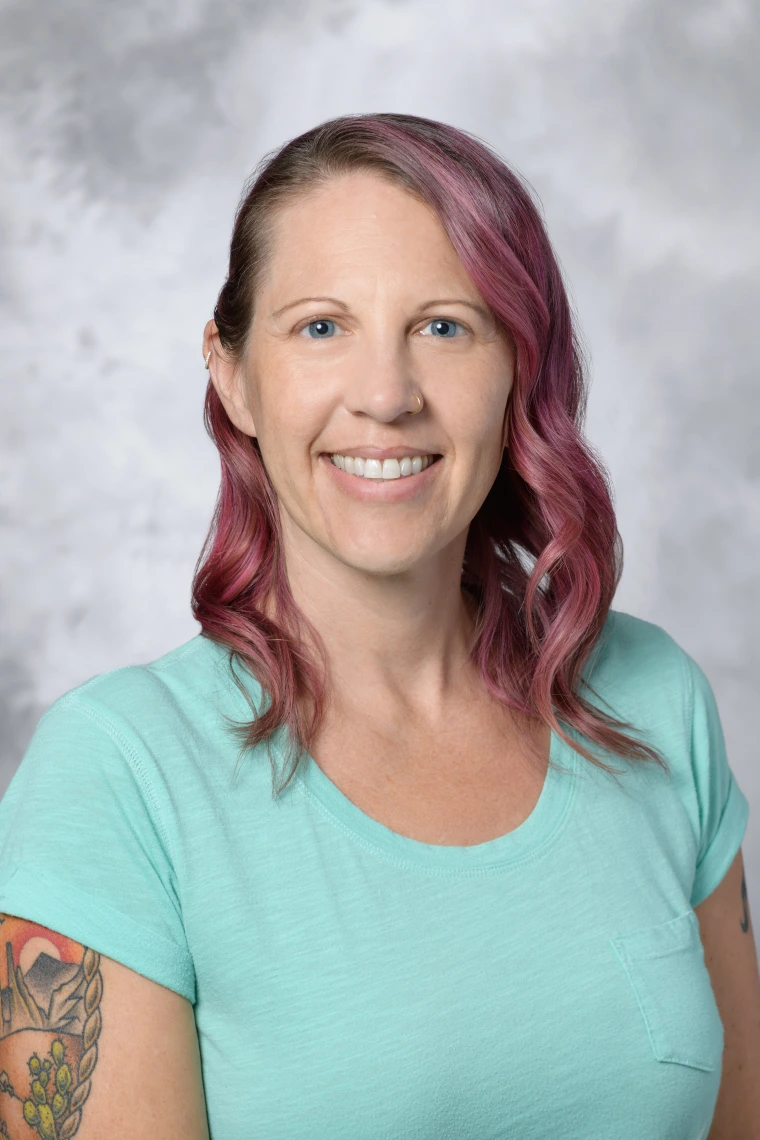 Woman smiling and wearing a teal t-shirt